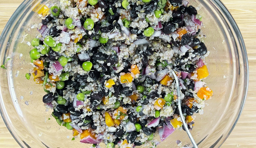 Quinoa,black bean and Green pea salad ingredients mixture in a bowl