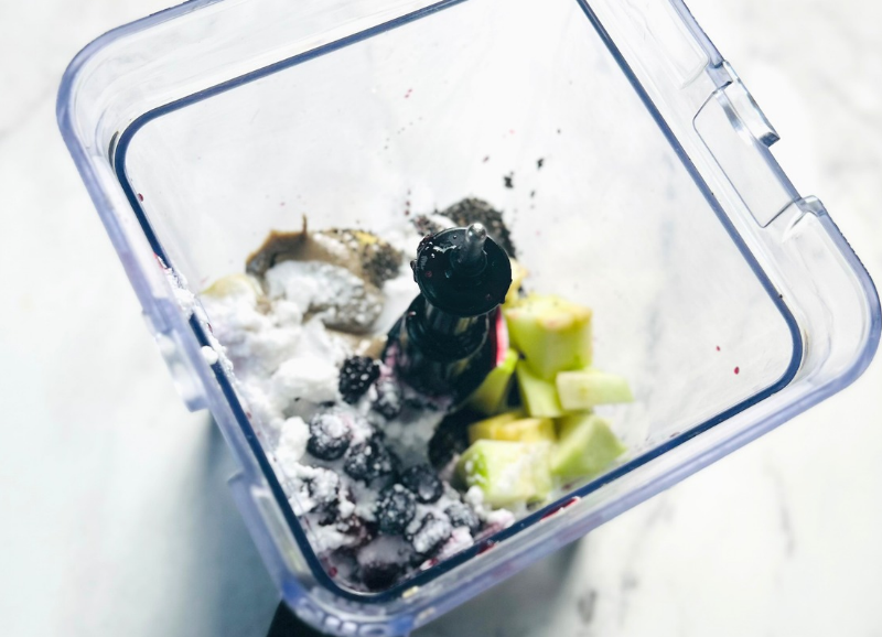 Mixed berry smoothie bowl ingredients in a blender